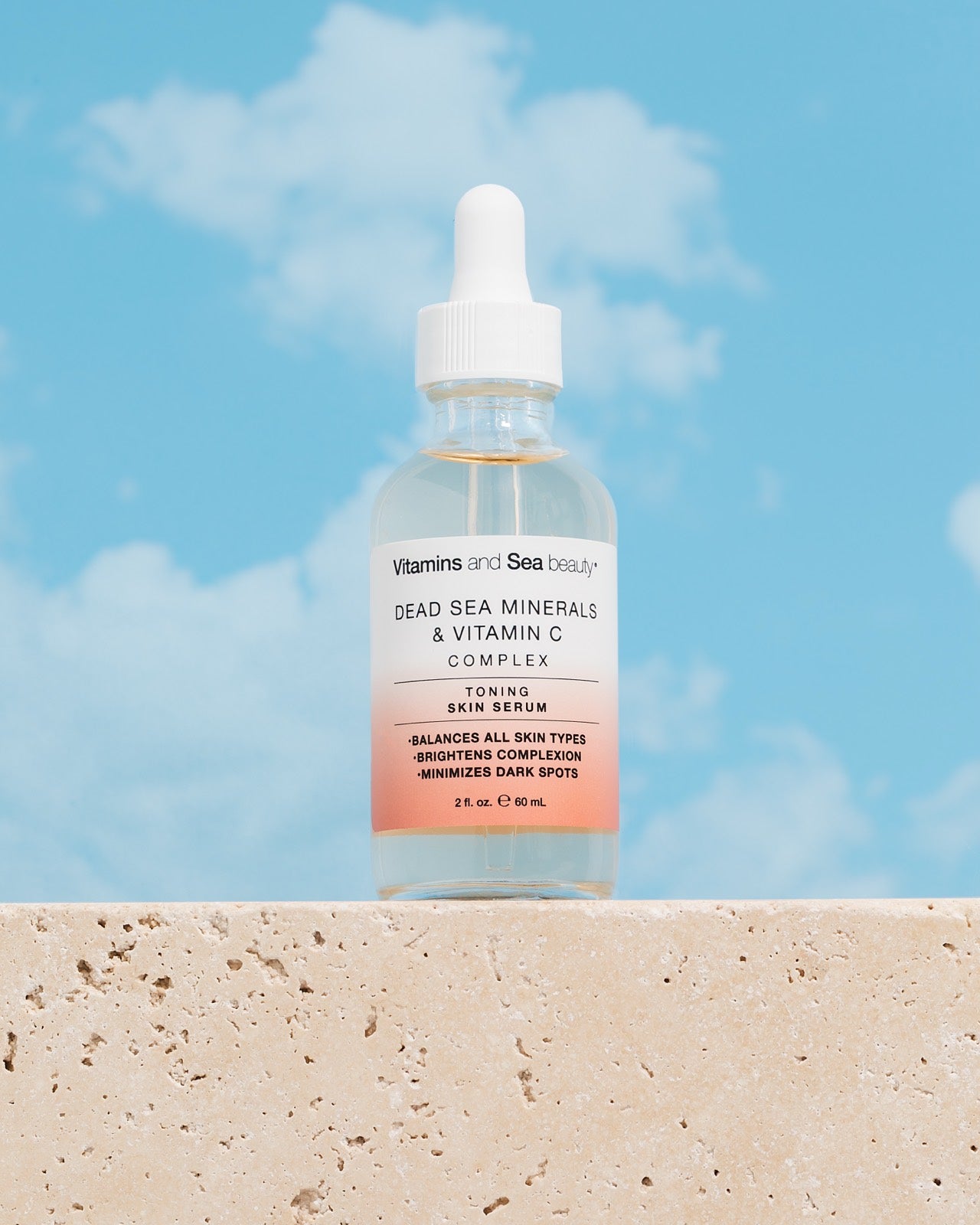 Blue Sea Kale cleanser on a sand ledge against a sky-blue wall